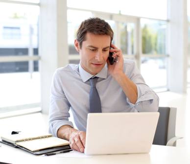 Portrait of businessman talking on mobile phone in office